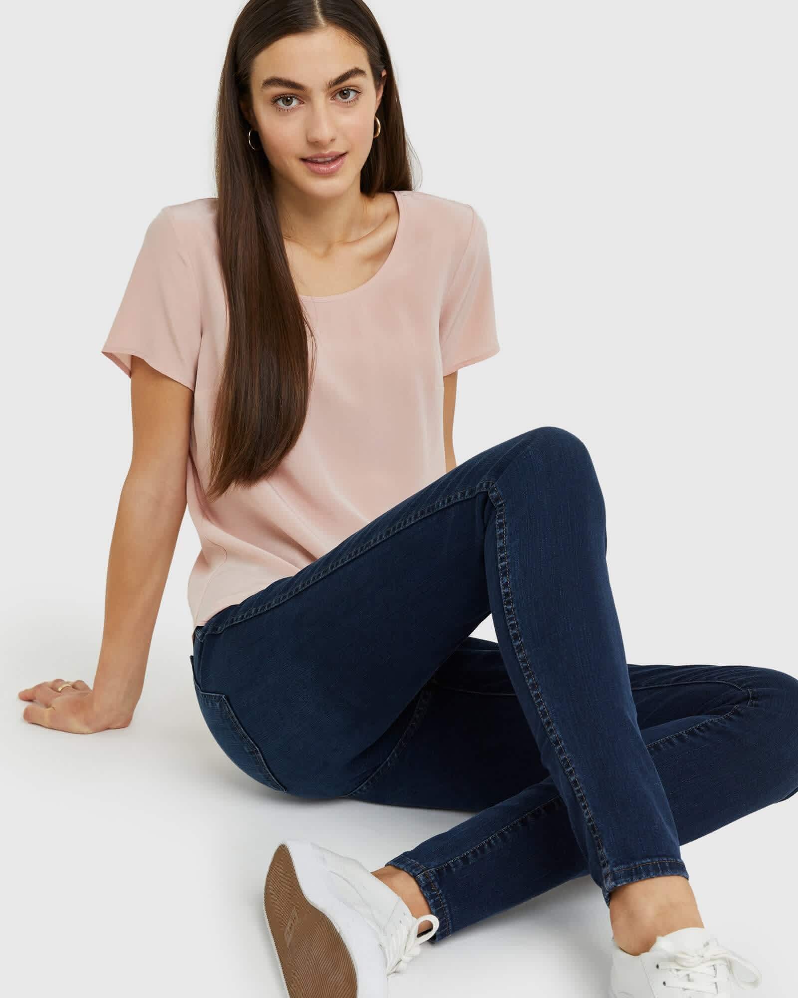 Woman wearing silk tee in pink sitting