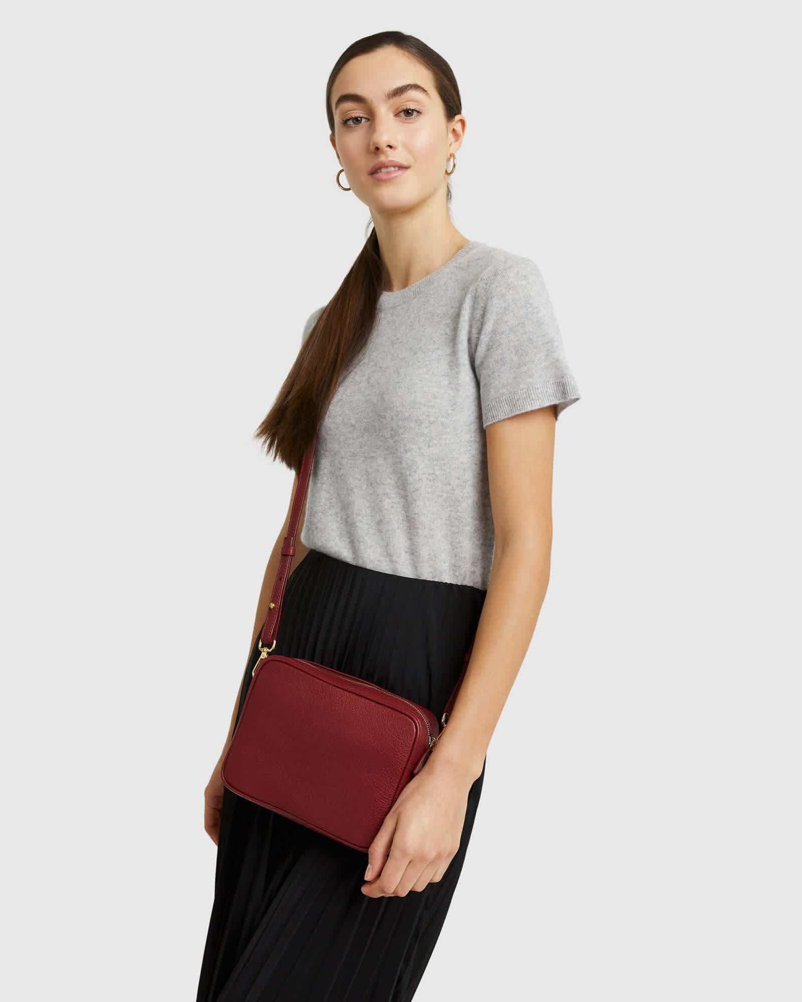 woman wearing Italian leather crossbody bag in red standing