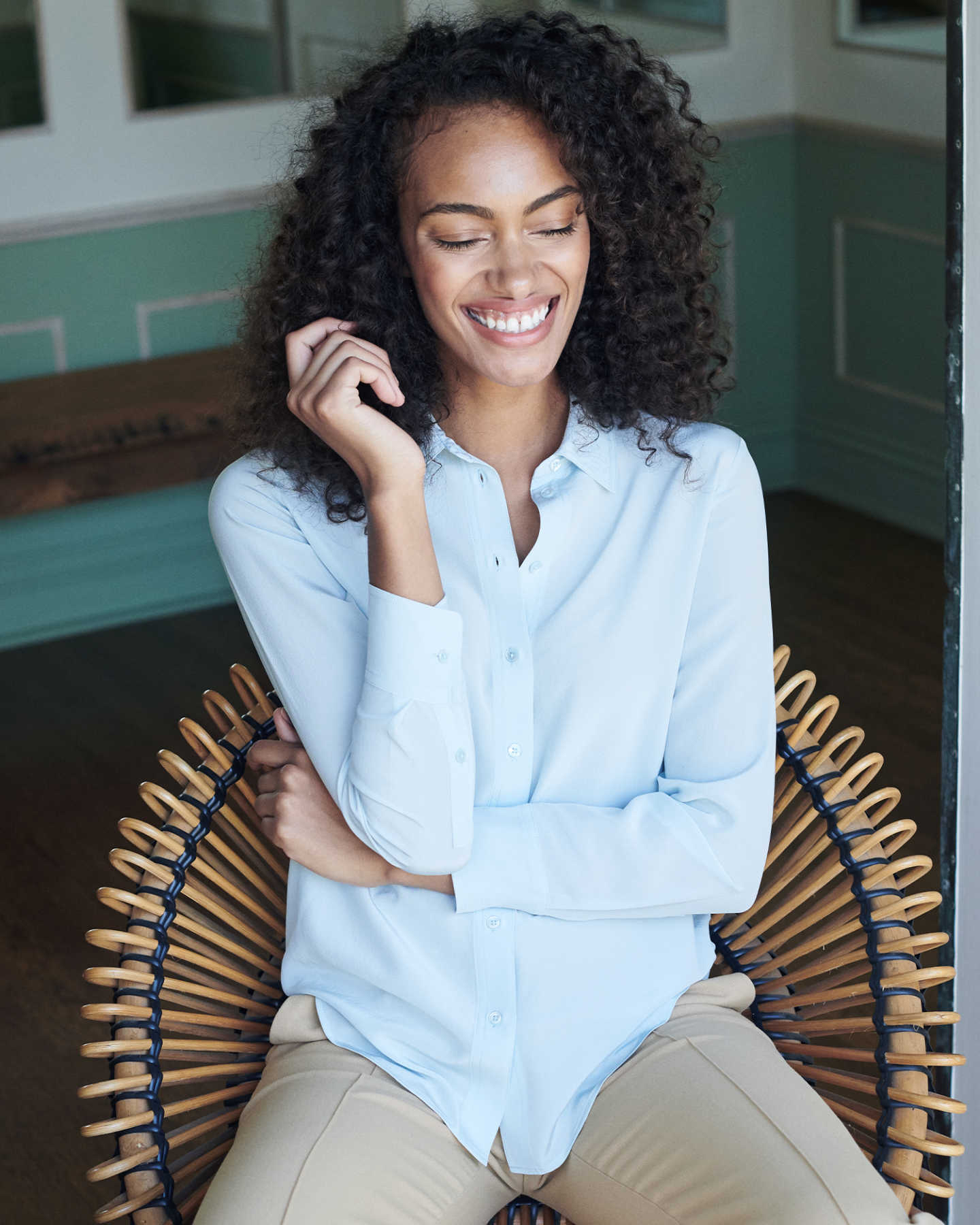 Woman wearing washable silk blouse in blue smiling