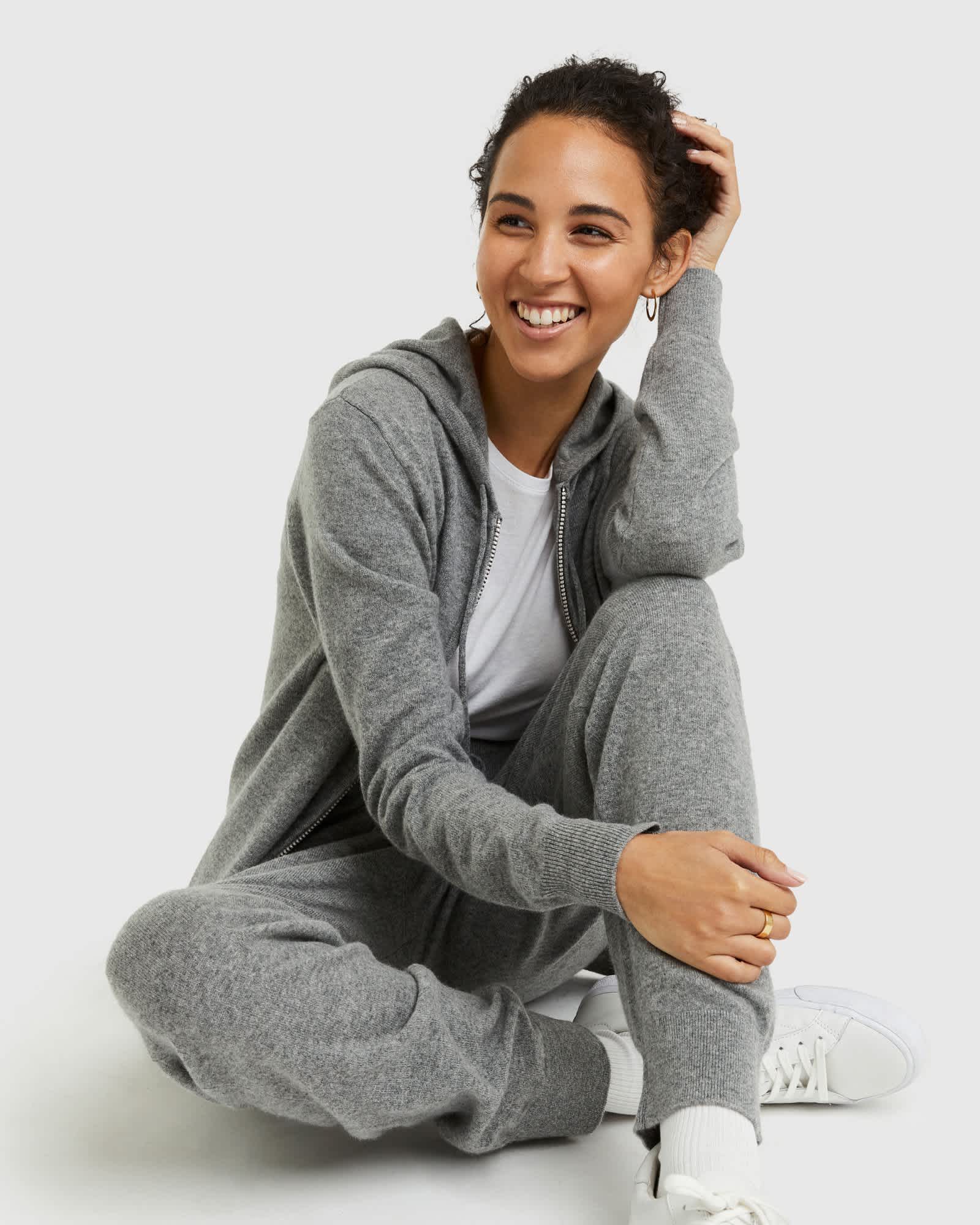 Woman wearing grey cashmere zip hoodie and matching cashmere sweatpants