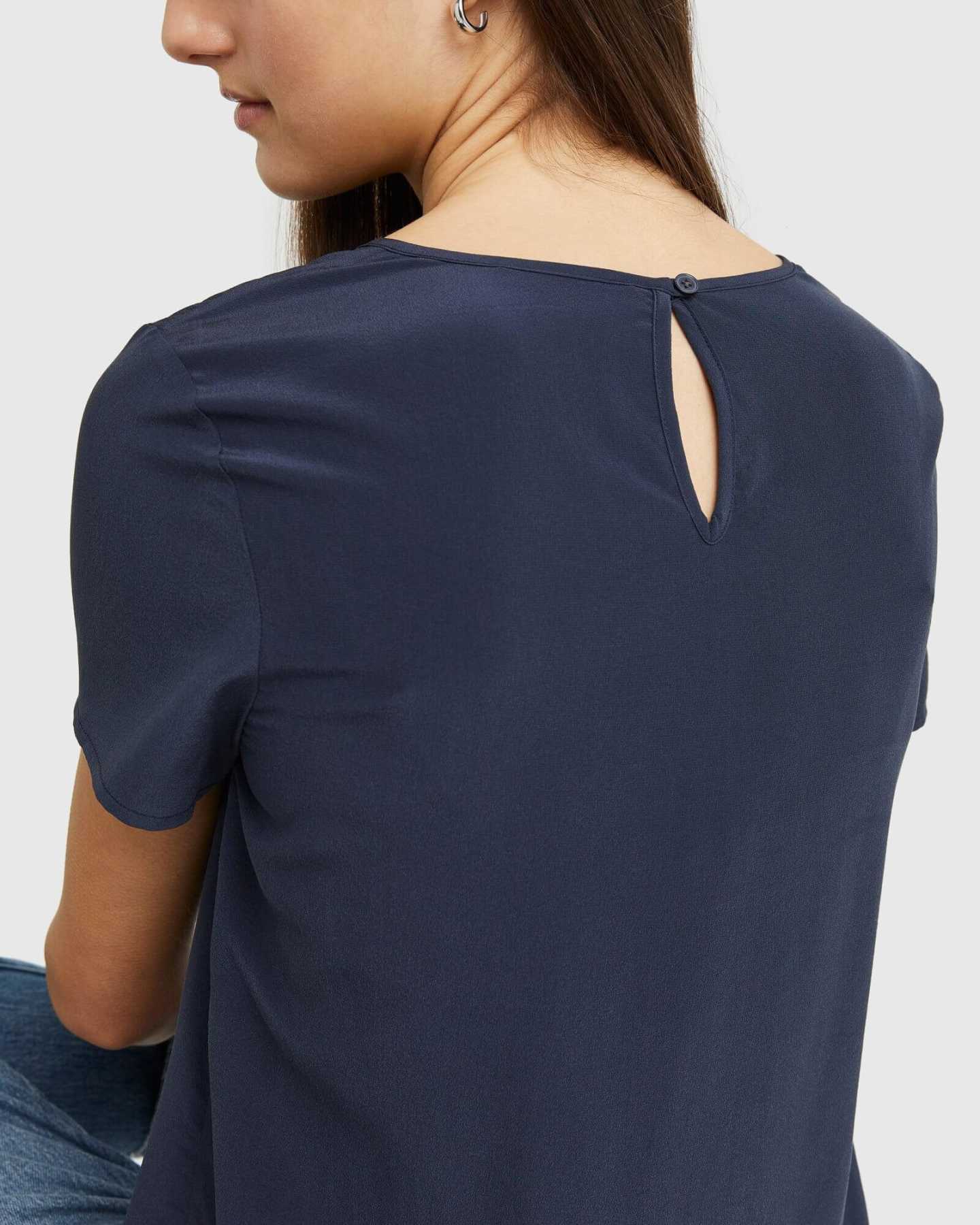 Woman wearing silk tee in navy from back