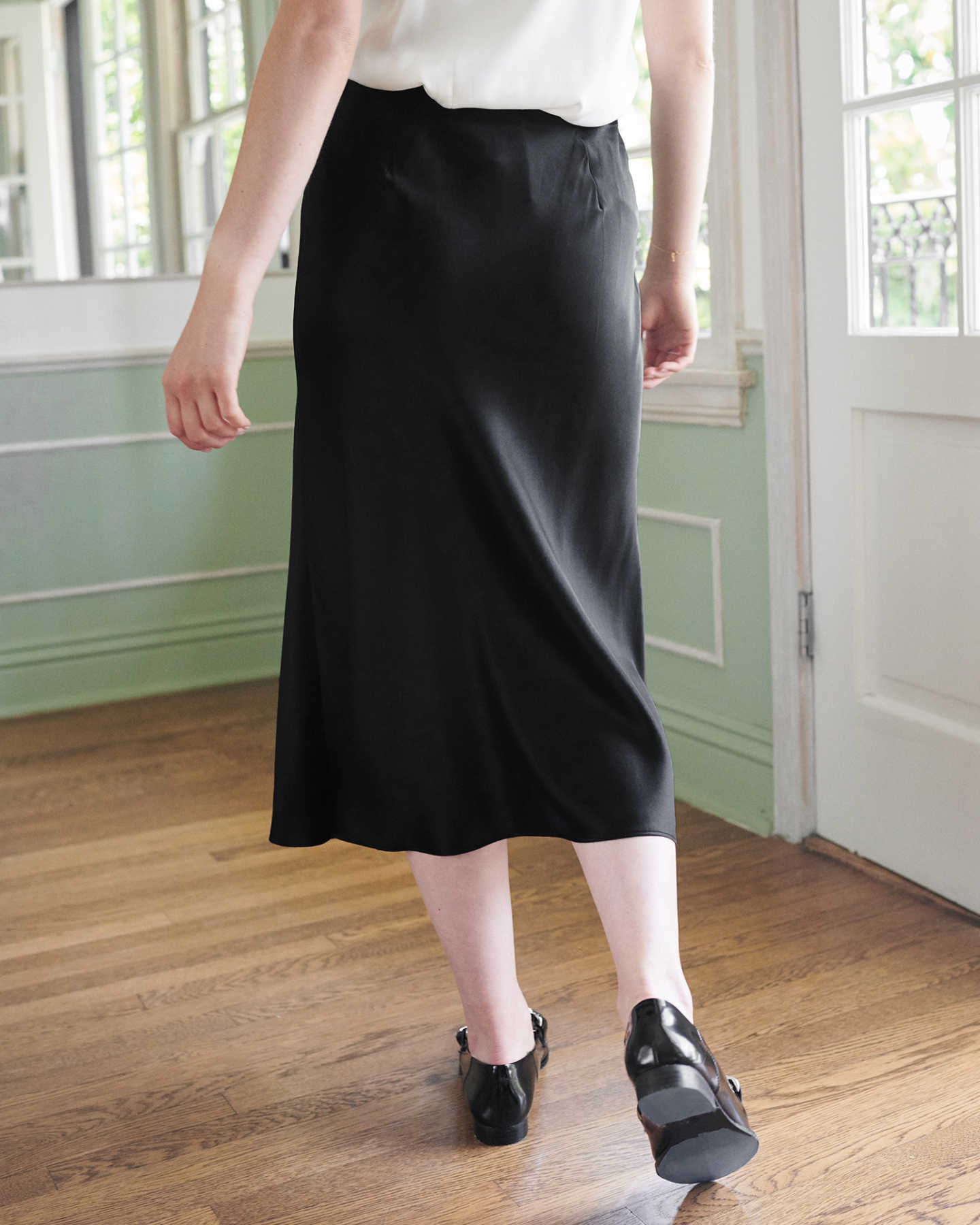 Woman wearing black silk skirt from back