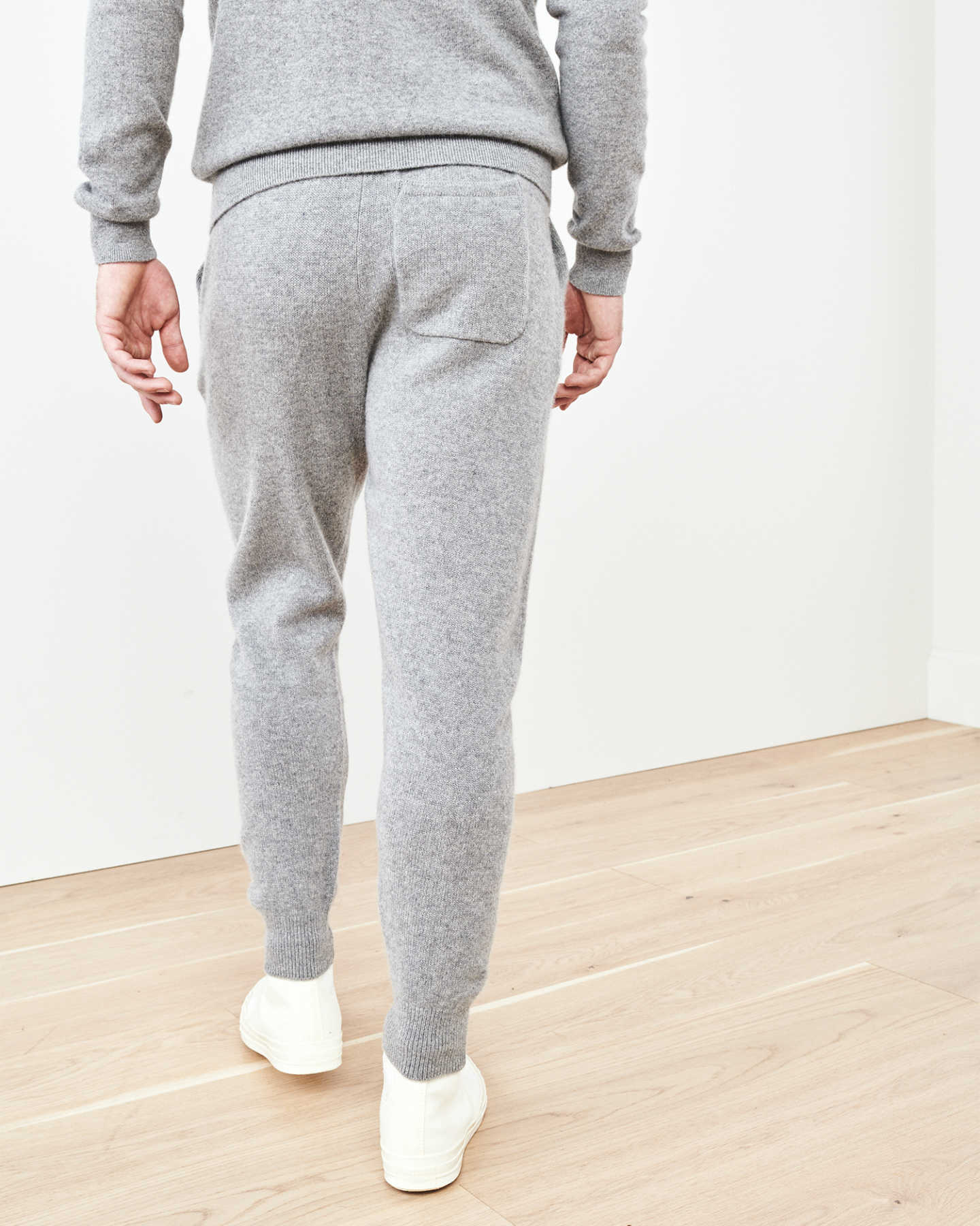 Man wearing cashmere men's cashmere joggers / cashmere sweatpants in grey from back