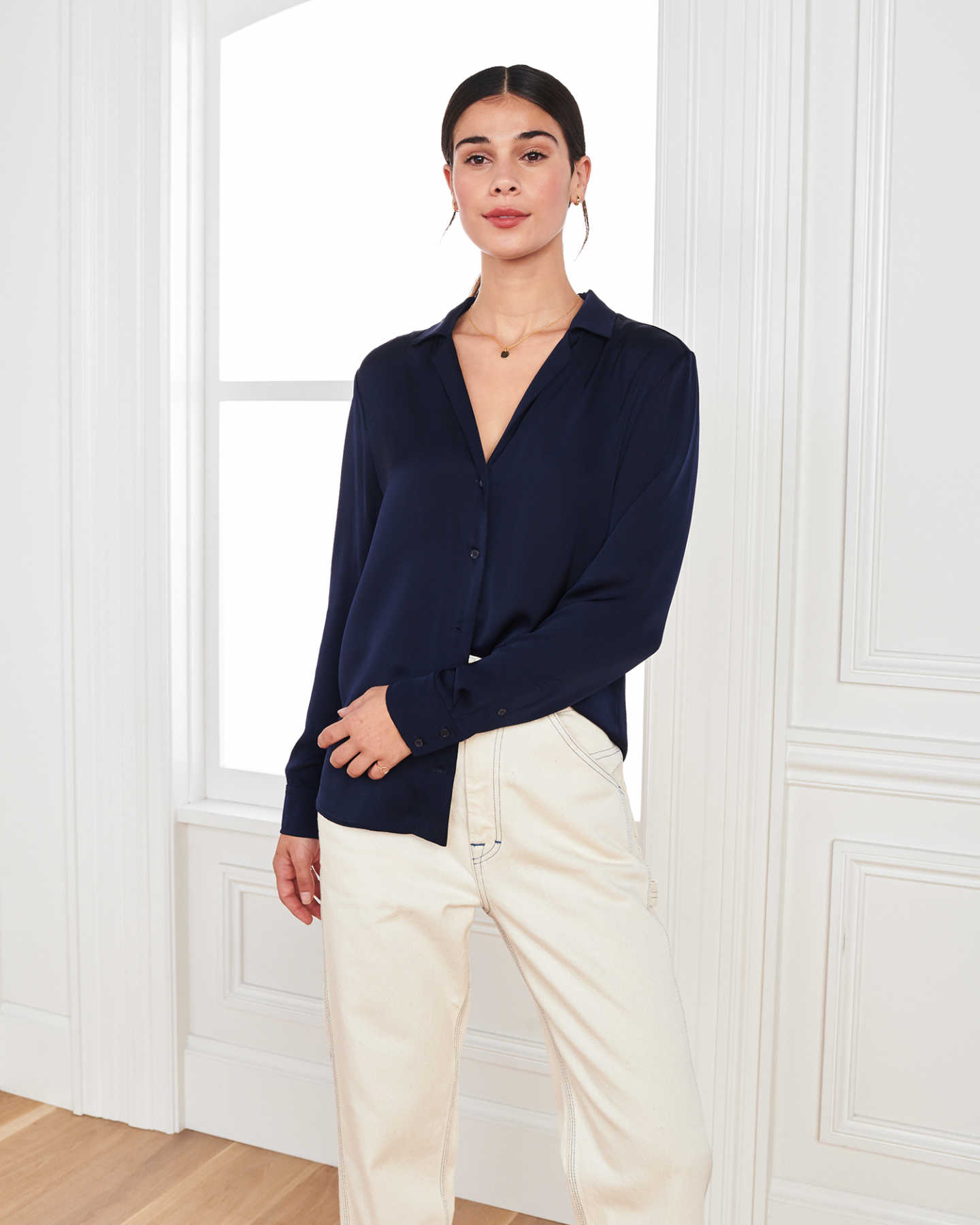 woman wearing silk notch collar blouse in navy by window