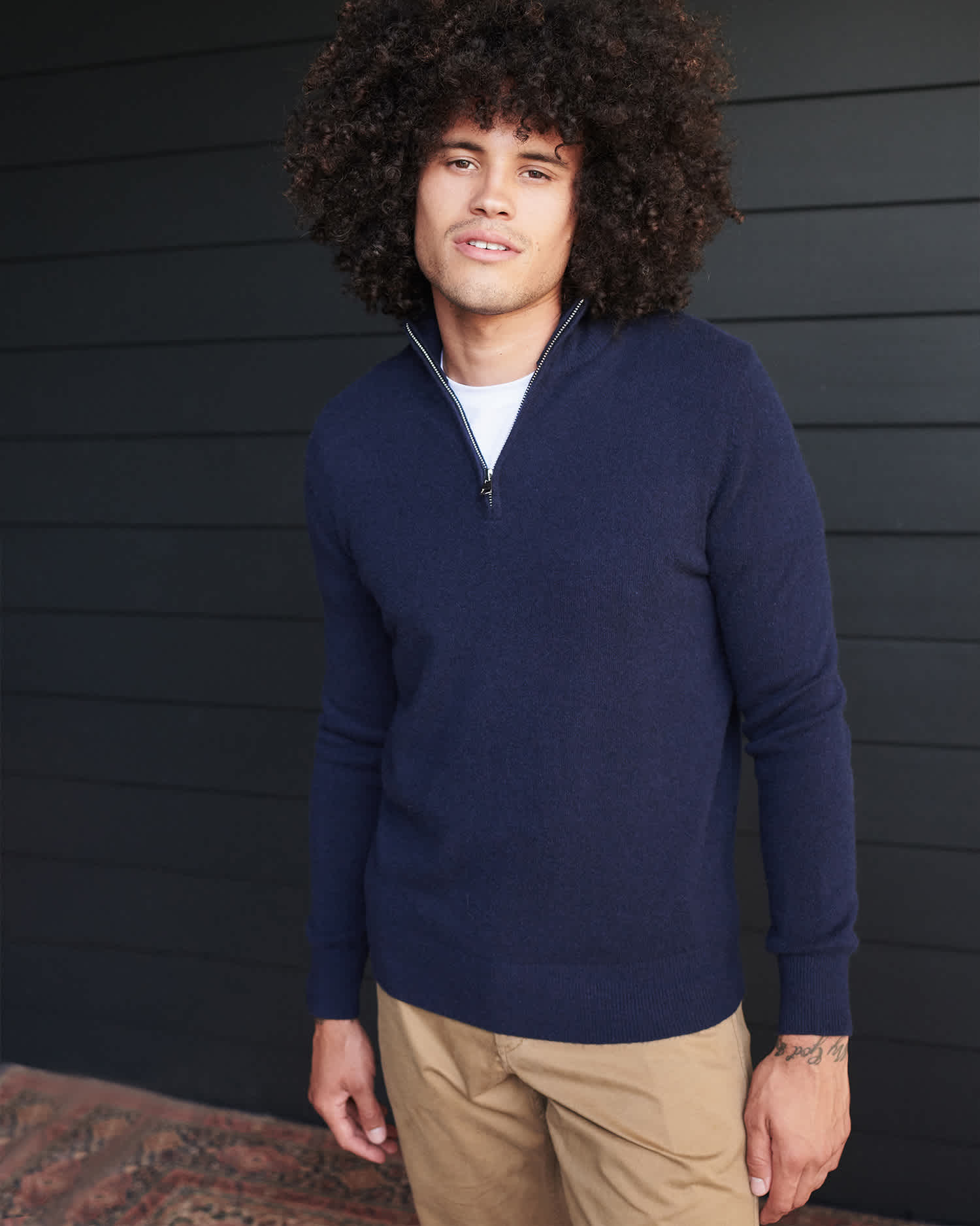 Man wearing navy cashmere quarter zip sweater smiling