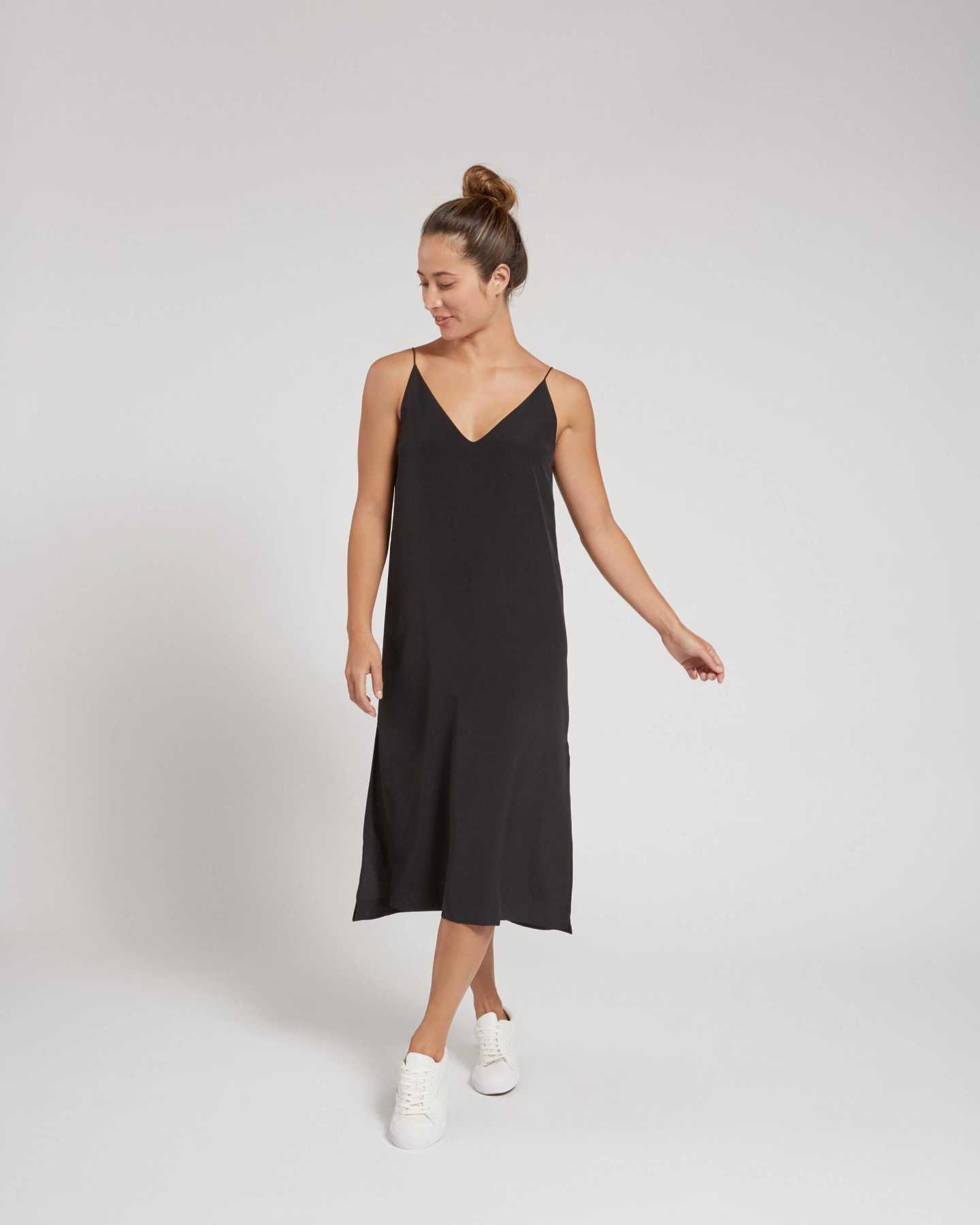 Woman wearing black silk slip dress from front