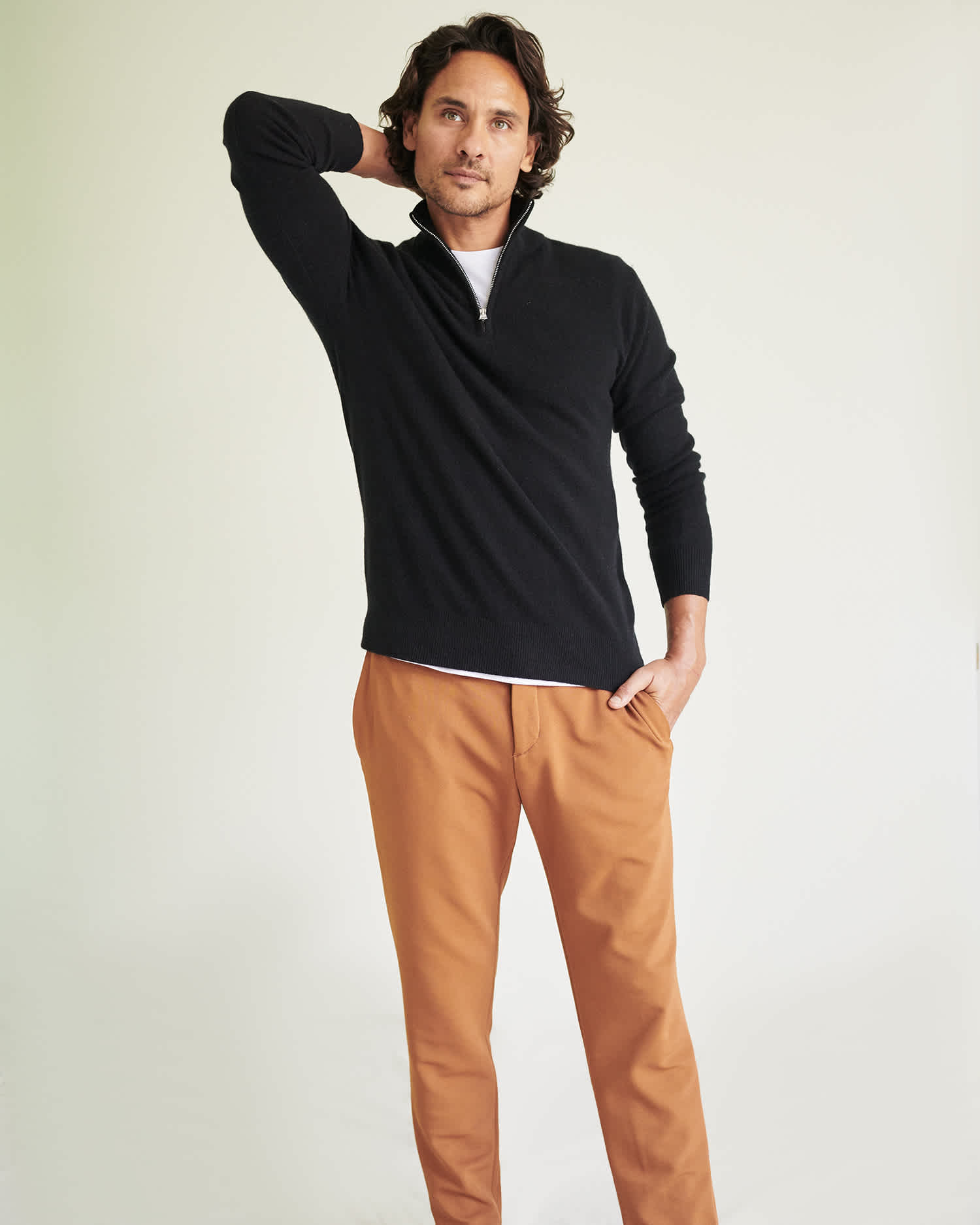 Man wearing black cashmere quarter zip sweater standing