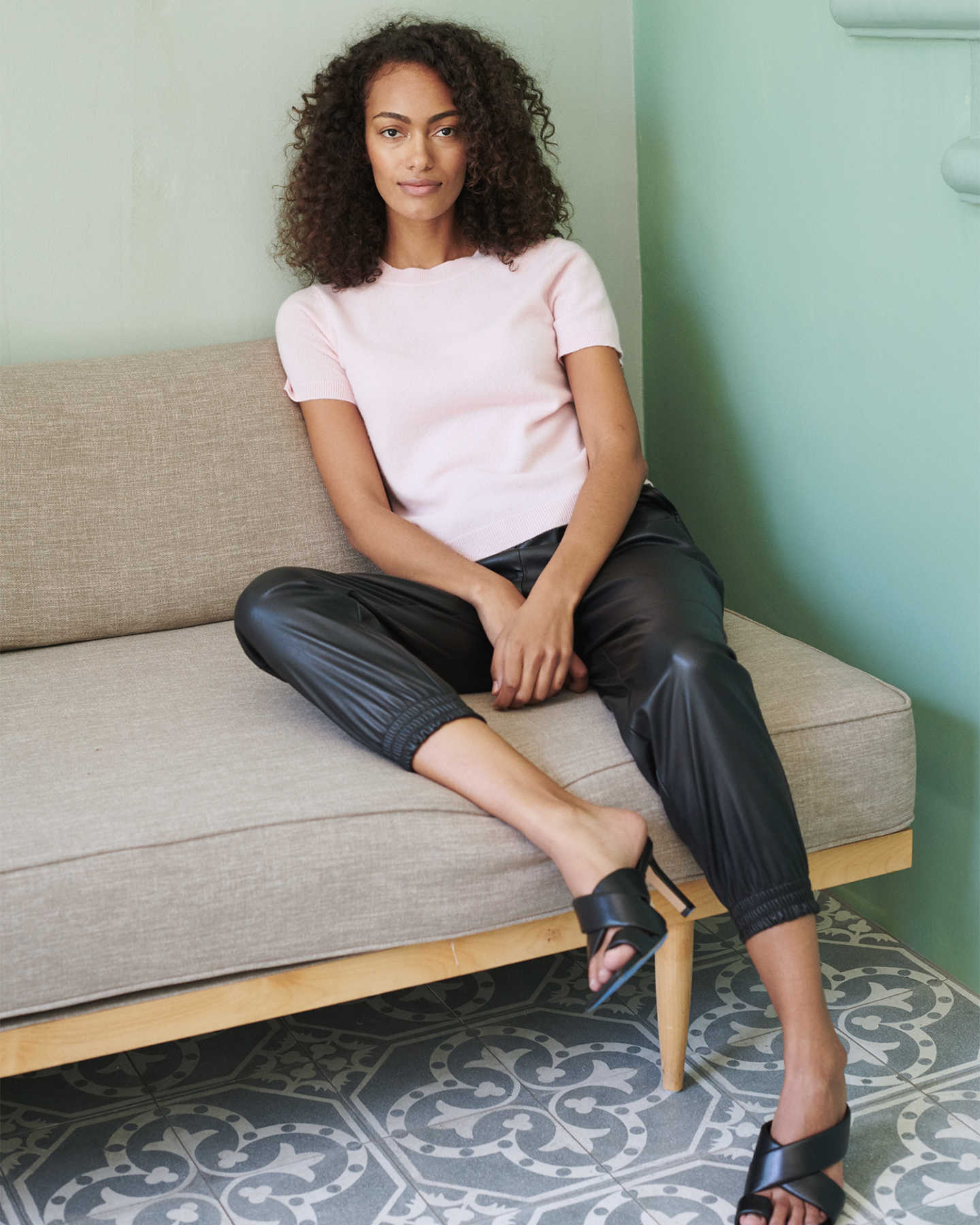woman wearing pink cashmere tee and short sleeve cashmere sweater on couch