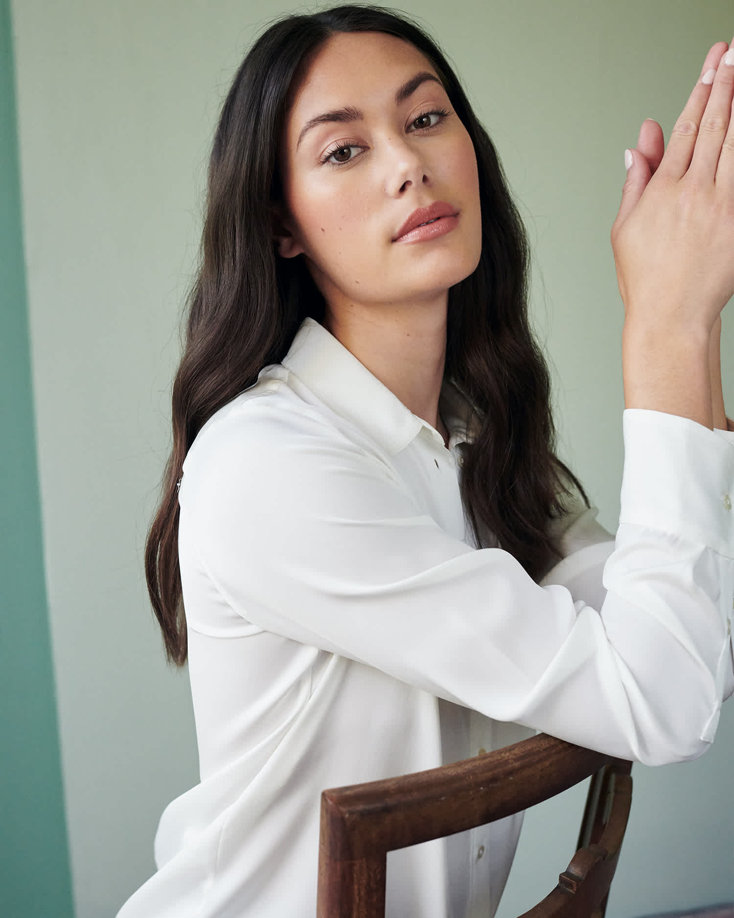 Woman wearing ivory silk blouse that is washable looking at camera