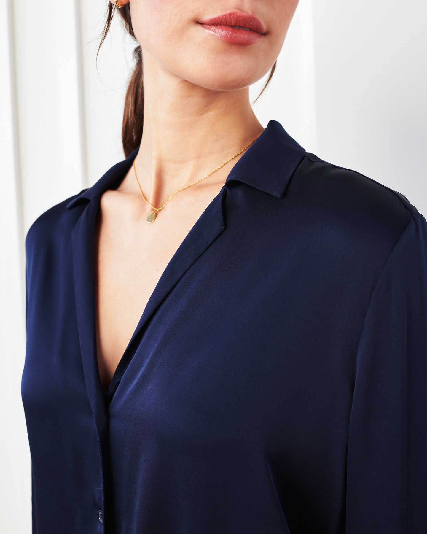 woman wearing silk notch collar blouse in navy zoomed in