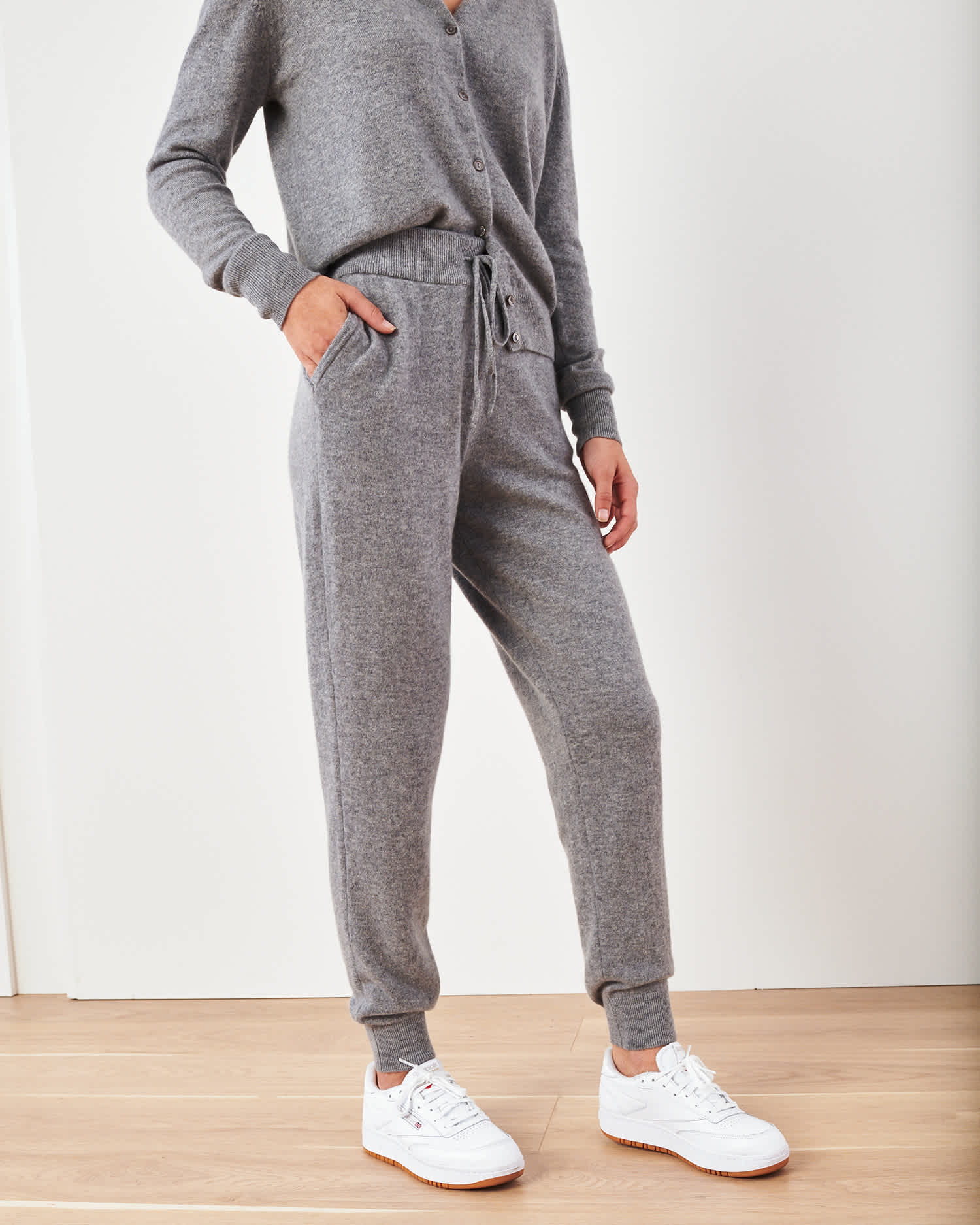 Woman wearing grey cashmere sweatpants & cashmere joggers standing