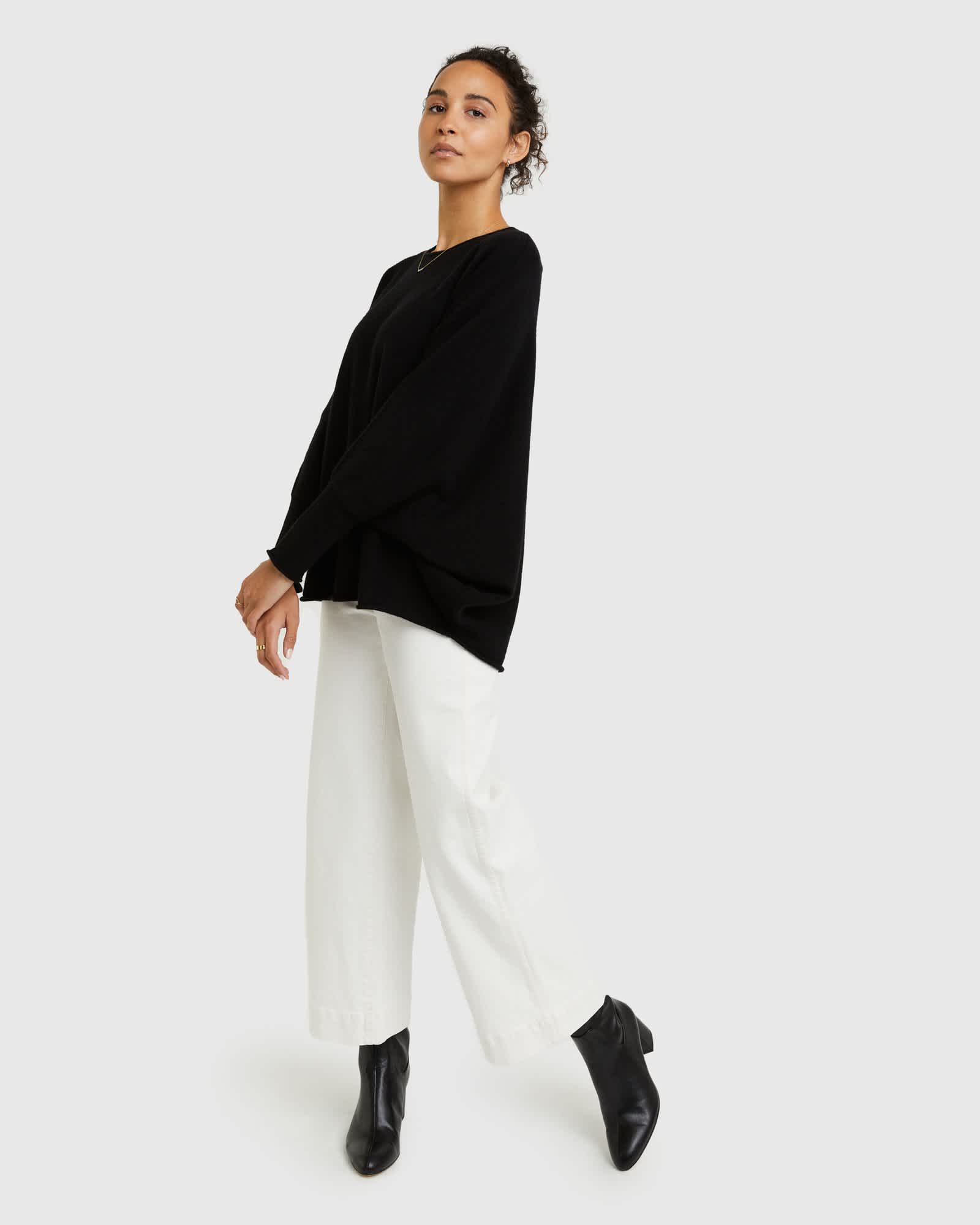 Woman wearing batwing sweater made from cashmere in black from the side