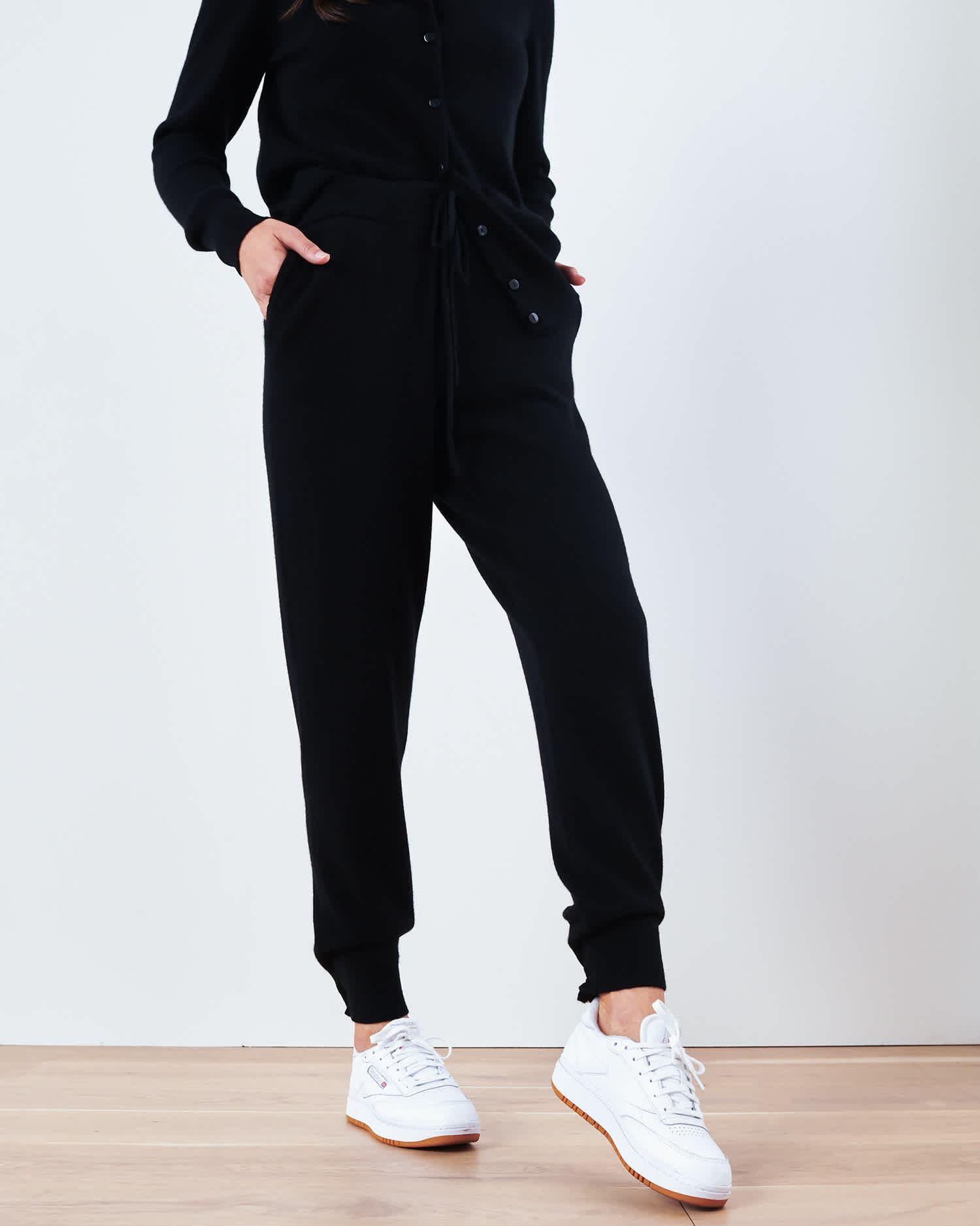 Woman wearing black cashmere sweatpants & cashmere joggers with white sneakers