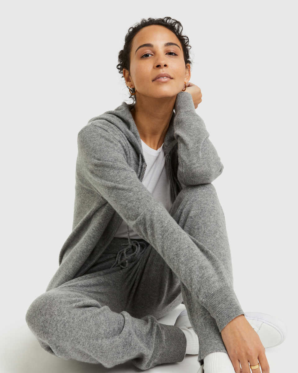 Woman wearing grey cashmere sweatpants and a matching grey cashmere zip up hoodie