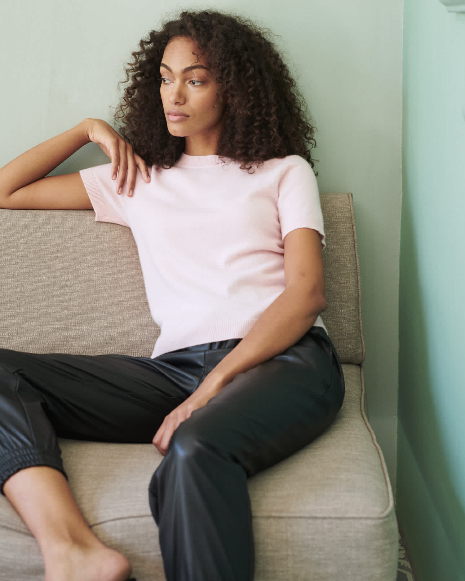 woman wearing pink cashmere tee and short sleeve cashmere sweater lounging