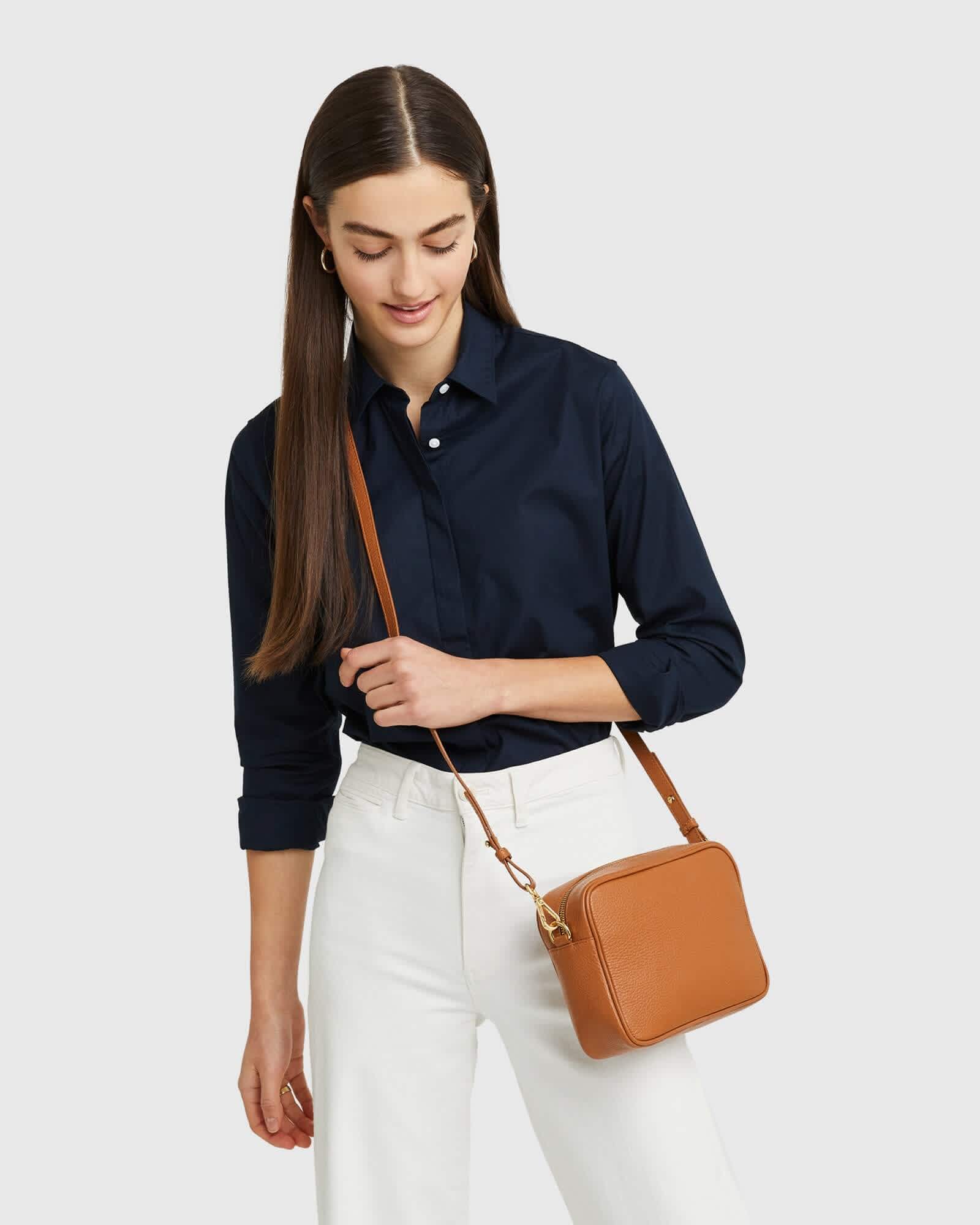 woman wearing Italian leather crossbody bag in brown and blue blouse