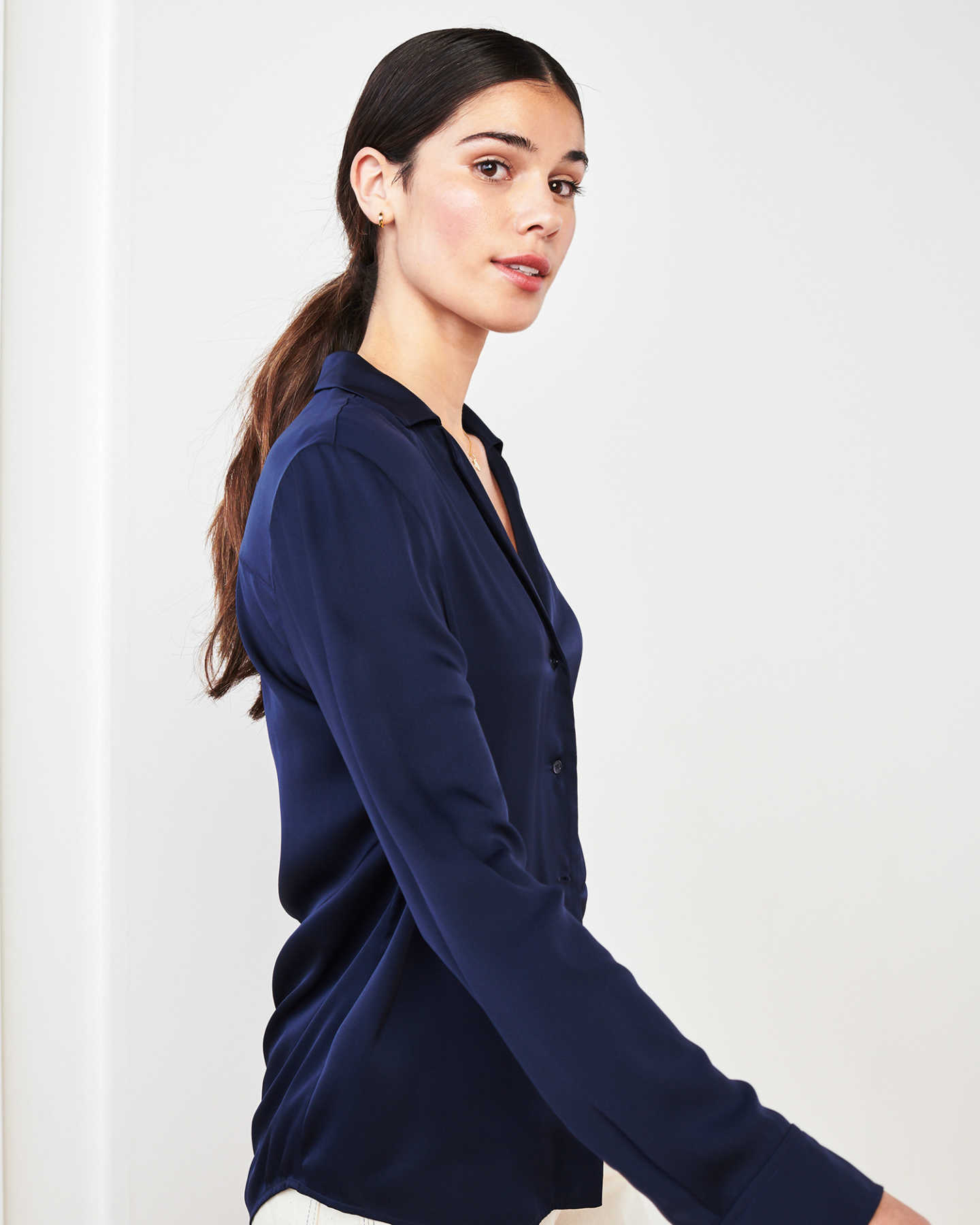 woman wearing silk notch collar blouse in navy walking