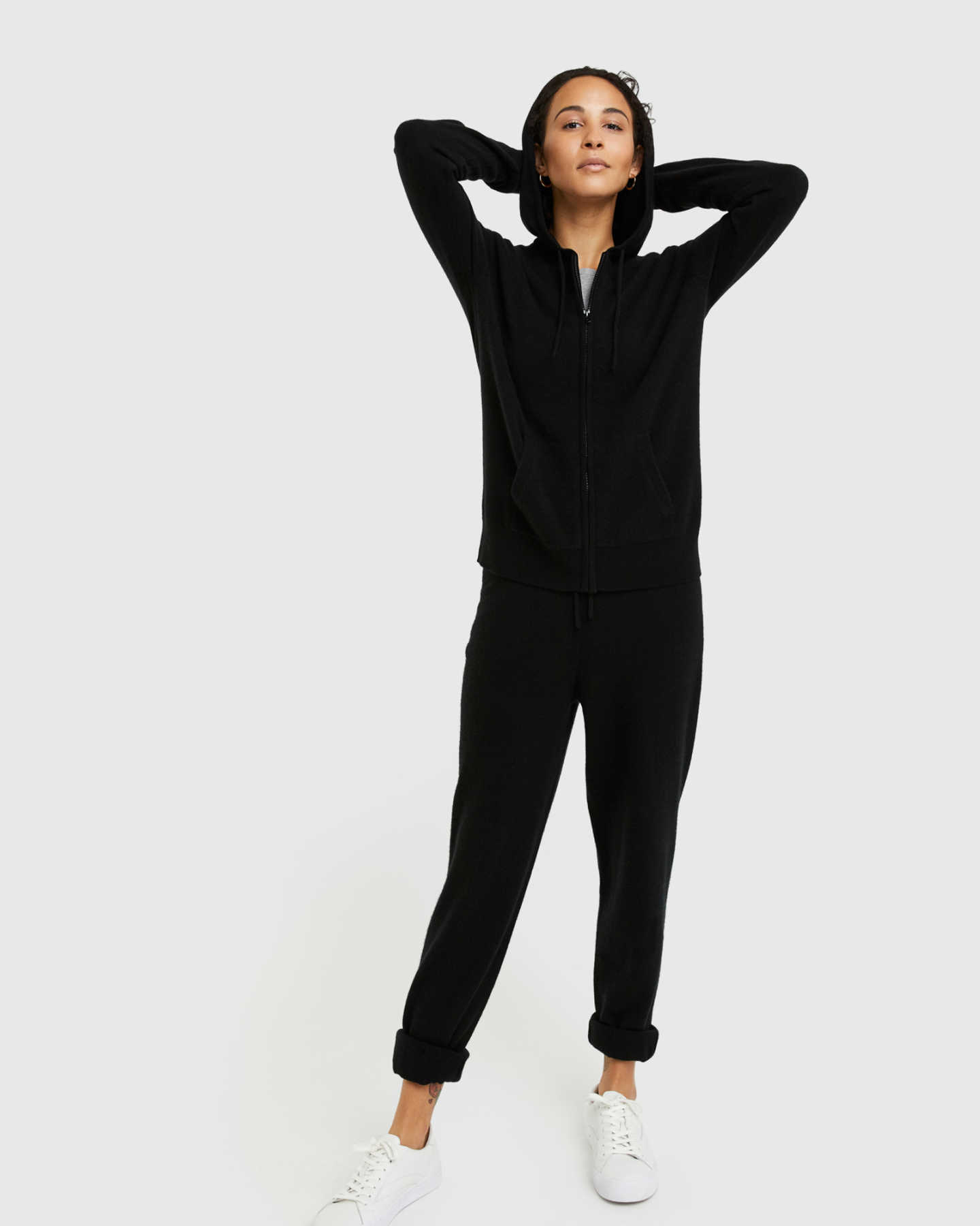 Woman wearing black cashmere zip hoodie and matching cashmere sweatpants