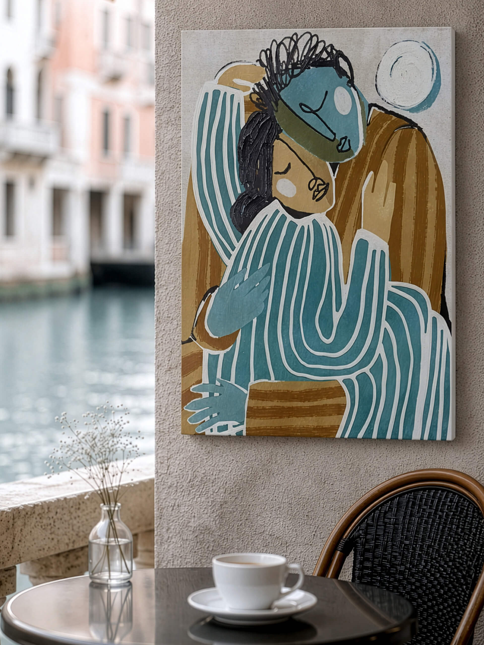 Café am Kanal mit Tasse, Vase und einem abstrakten Bild von zwei umarmten Figuren an der Wand.