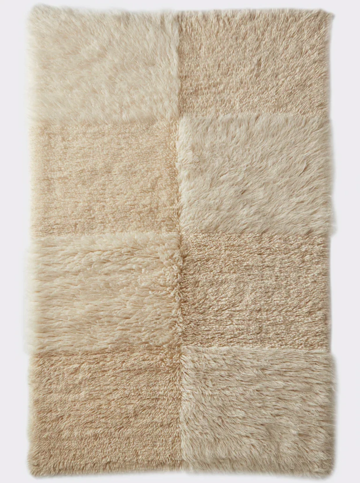 Beiger Teppich mit weicher, flauschiger Textur und einem quadratischen Muster.