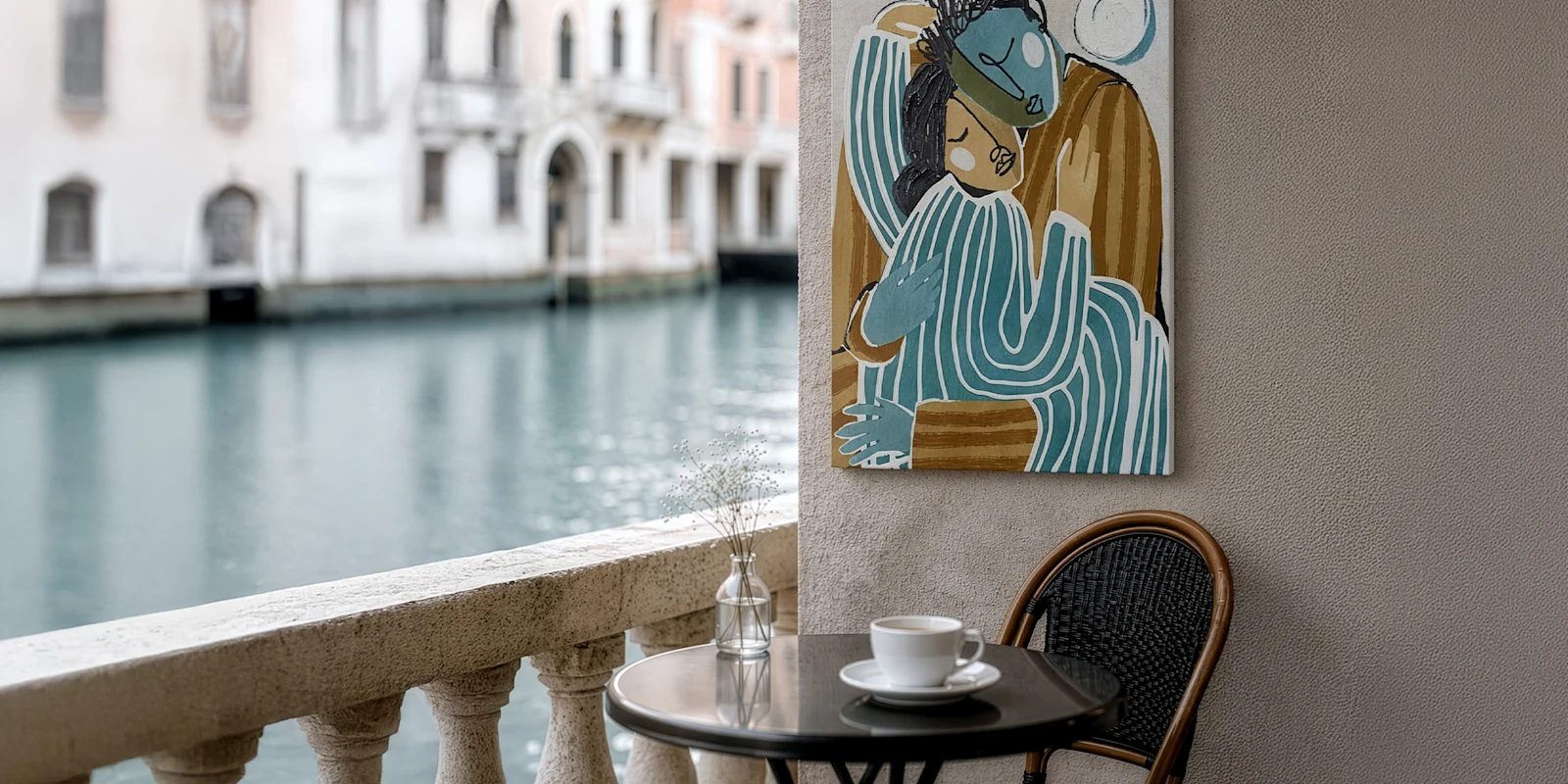Café am Kanal mit Tasse, Vase und einem abstrakten Bild von zwei umarmten Figuren an der Wand.