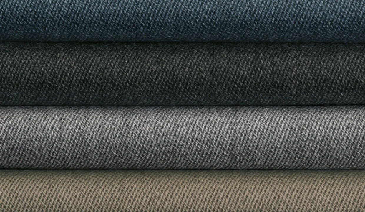 Gestapelde stoffen in vier kleuren: donkerblauw, donkergrijs, lichtgrijs en beige. Gestapelde stoffen in vier kleuren: donkerblauw, donkergrijs, lichtgrijs en beige.
