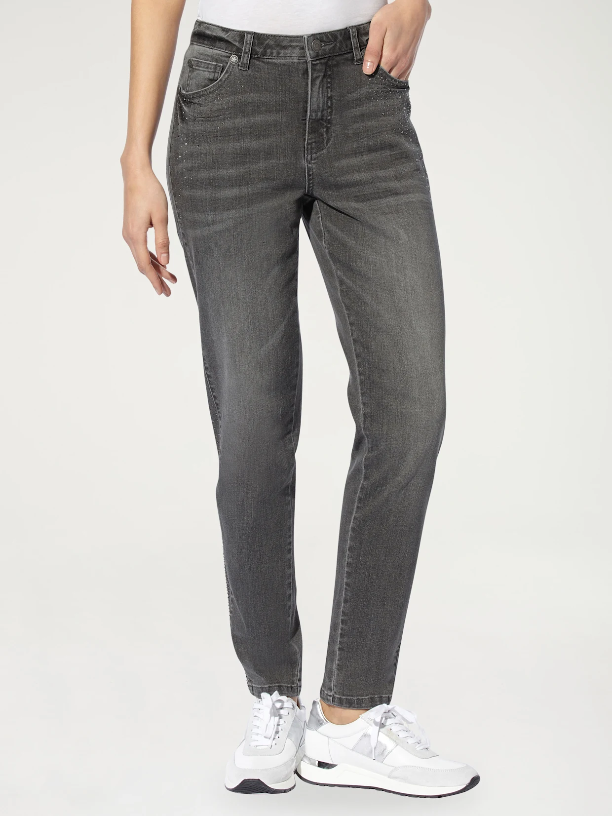 Jeans gris pour femmes avec un discret détail scintillant, combiné avec des sneakers blanches. Jeans gris pour femmes avec un discret détail scintillant, combiné avec des sneakers blanches.