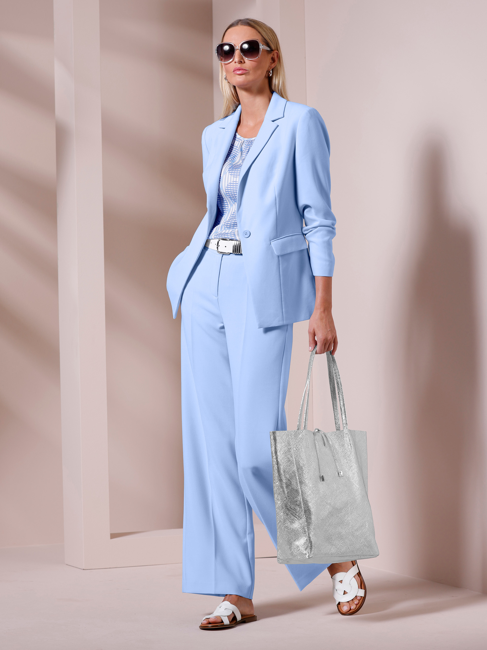 Un mannequin présente un tailleur-pantalon bleu décontracté.