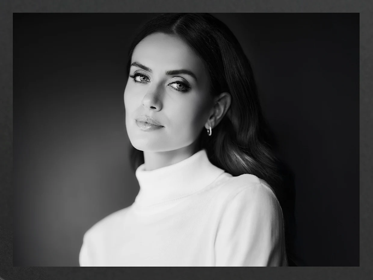 Un modèle aux longs cheveux lisses porte un pull à col roulé blanc, la photo est en noir et blanc et montre un gros plan. Un modèle aux longs cheveux lisses porte un pull à col roulé blanc, la photo est en noir et blanc et montre un gros plan.