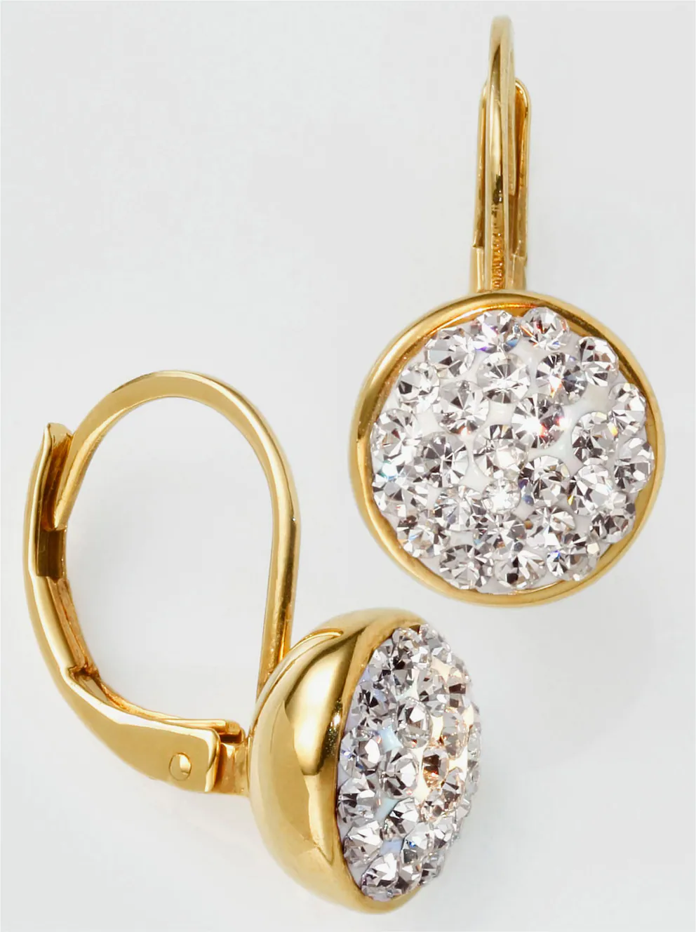 La photo représente une paire de boucles d'oreilles en or avec des cristaux clairs étincelants.