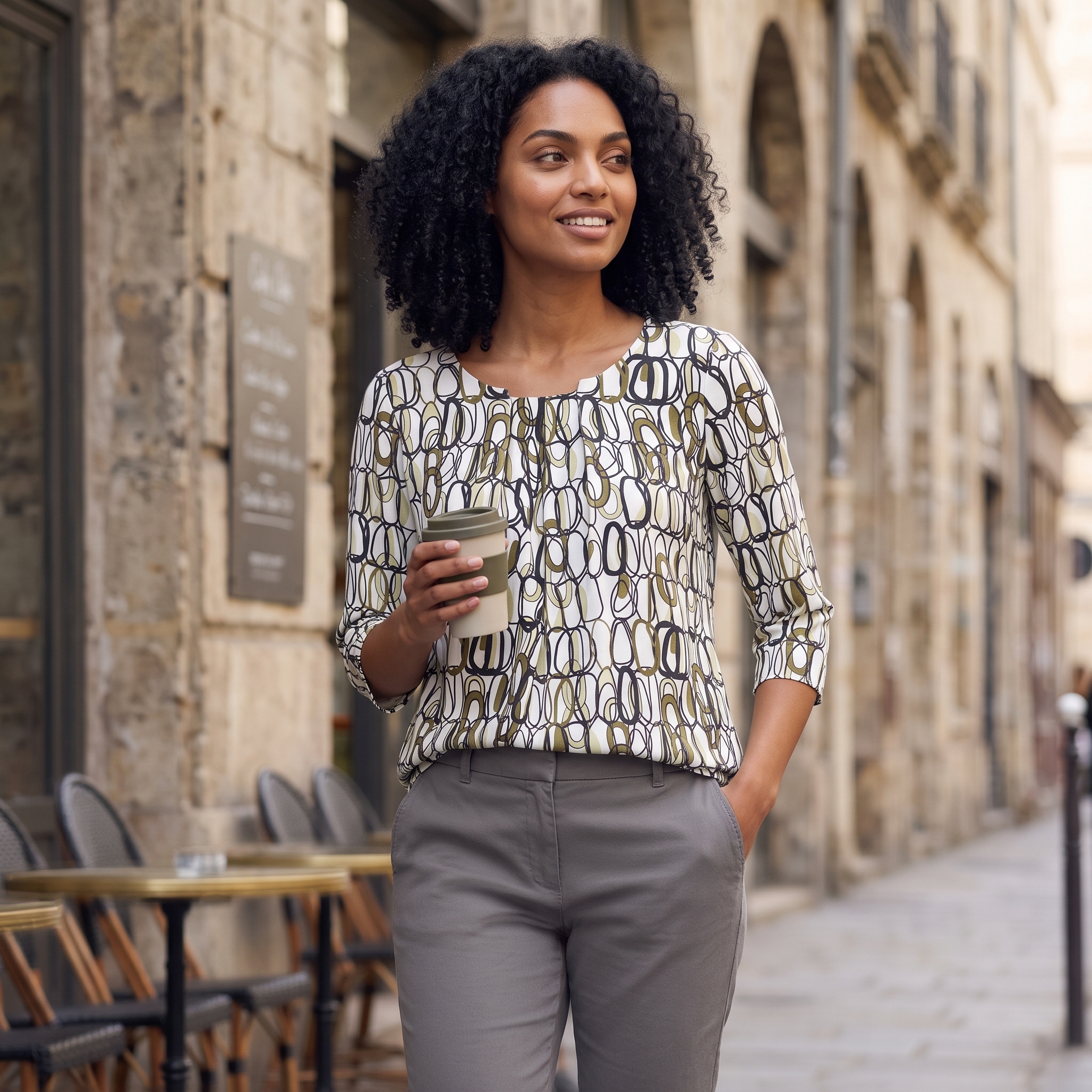 Elegante Bluse zu grauer Hose in einem stilvollen Café