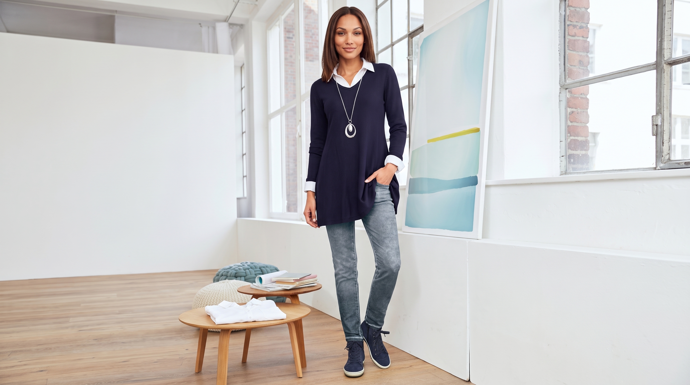 Femininer Lagenlook mit Bluse und Pullover an einer stilvollen Promenade