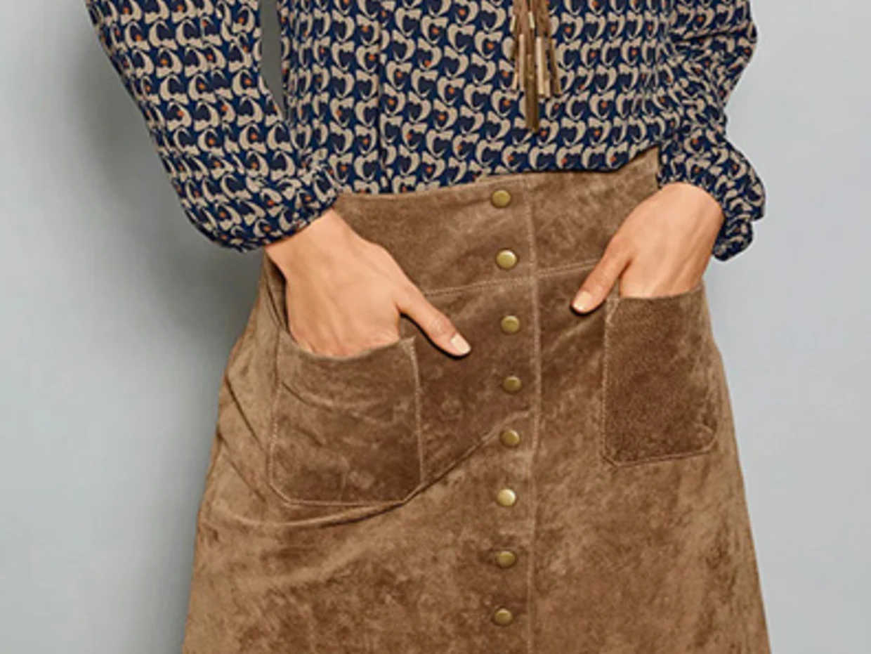 Brauner Cordrock mit Knopfleiste und grossen Taschen, kombiniert mit einer gemusterten Bluse in Blau.