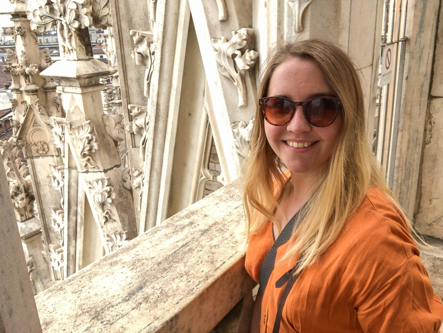 Ung dame på ferie med solbriller smiler til kamera