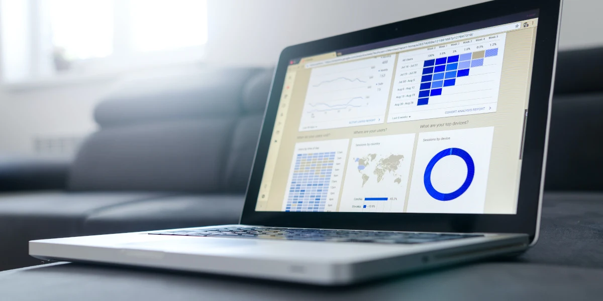 An image of a laptop with a report on it, including a range of different charts. 