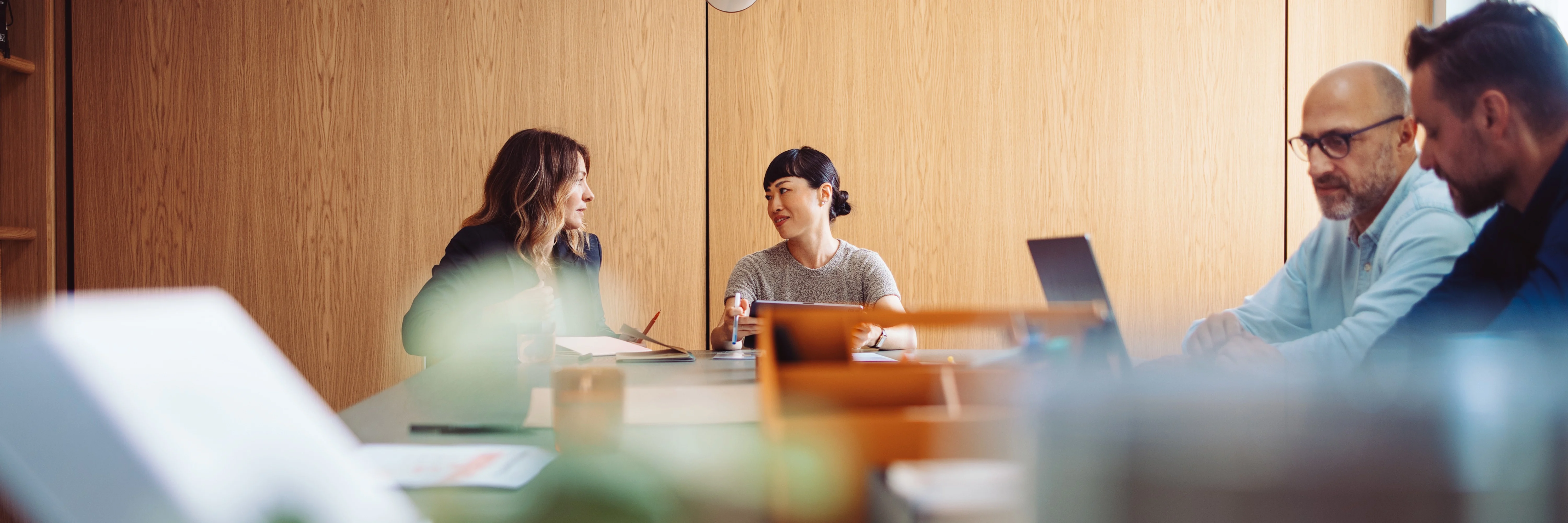 Four professionals in a meeting discussing ERP software