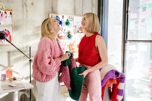 two-women-laughing-holding-chunky-knit