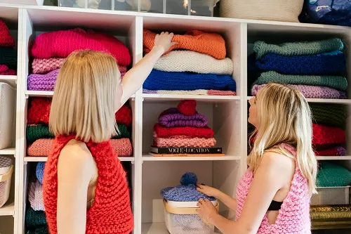 Two-women-arranging-knitwear-shelves