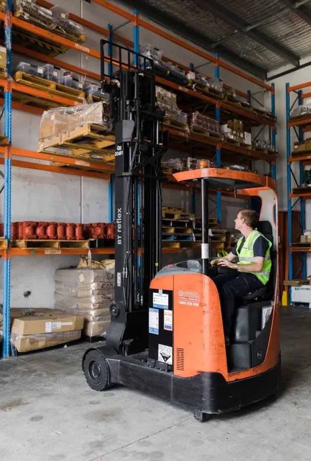 Man-driving-forklift-in-warehouse 