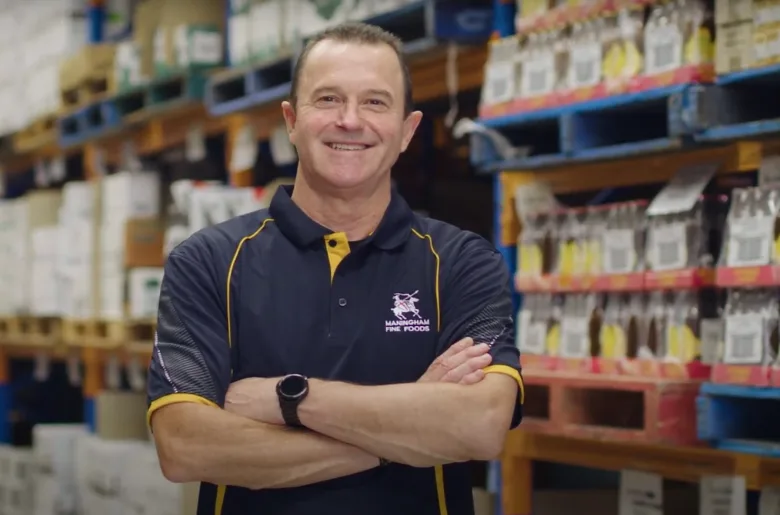 Man from Maningham Fine Foods, user of Butn invoice financing, stands smiling in warehouse 