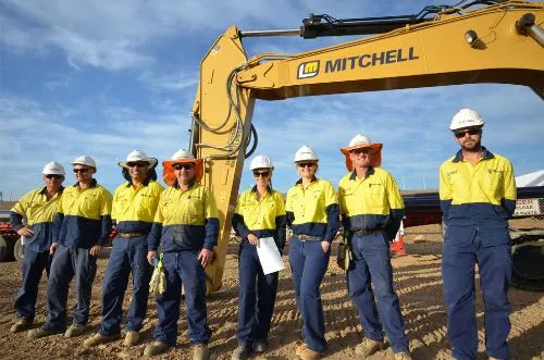 Mitchell-Waters-construction-workers-standing-in-front-of-branded-excavator