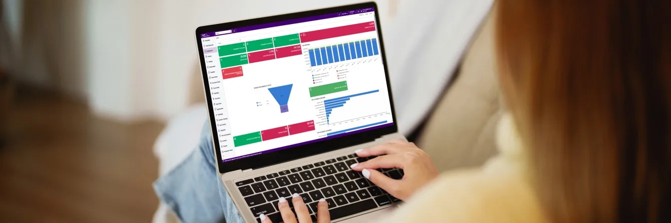 Person using laptop displaying colorful business analytics dashboard with charts, graphs and data visualizations.