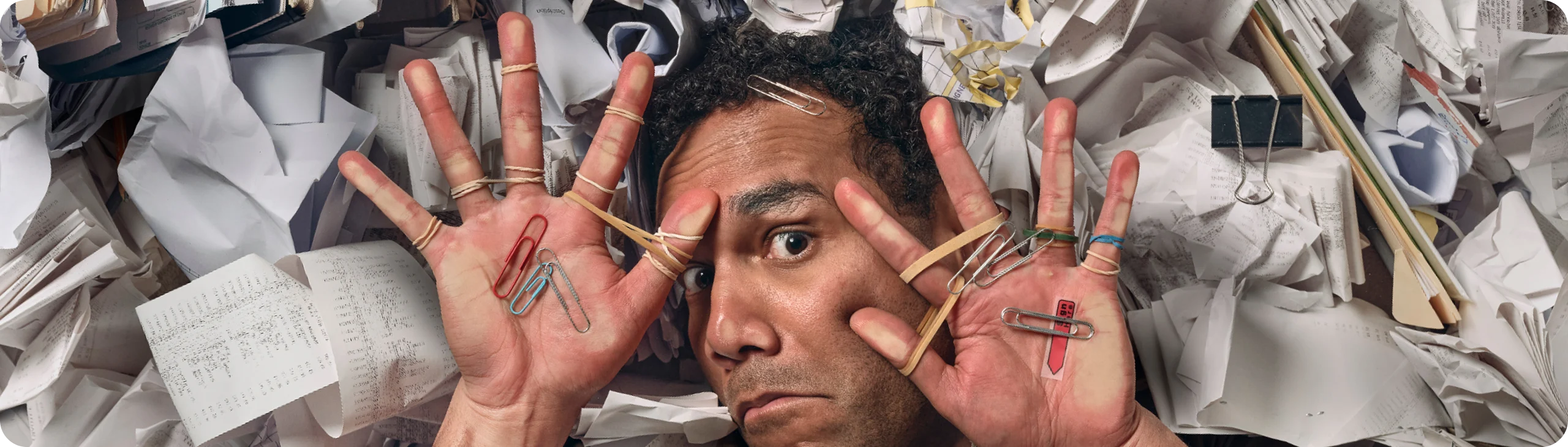Overwhelmed businessman in a cramped space, surrounded by receipts during tax time.