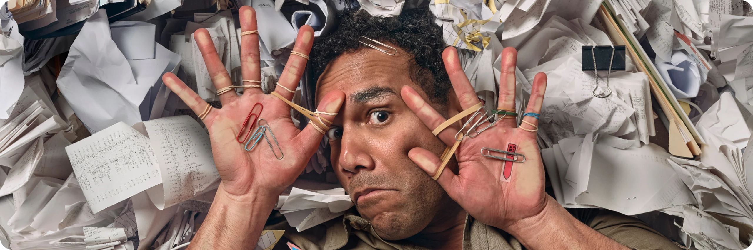 Overwhelmed businessman in a cramped space, surrounded by receipts during tax time.