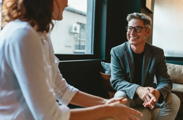 person smiling at client in professional suit and glasses