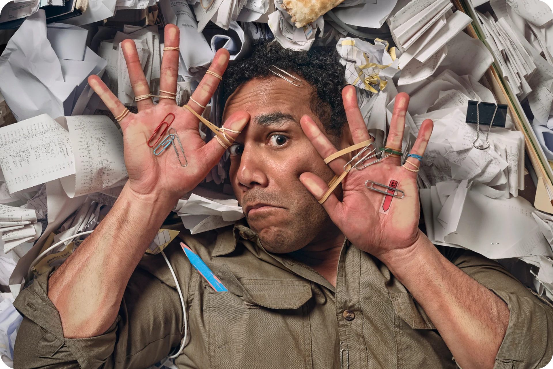 Overwhelmed businessman in a cramped space, surrounded by receipts during tax time.