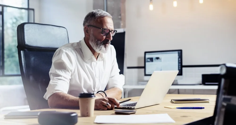 A business man working at his desk from a laptop