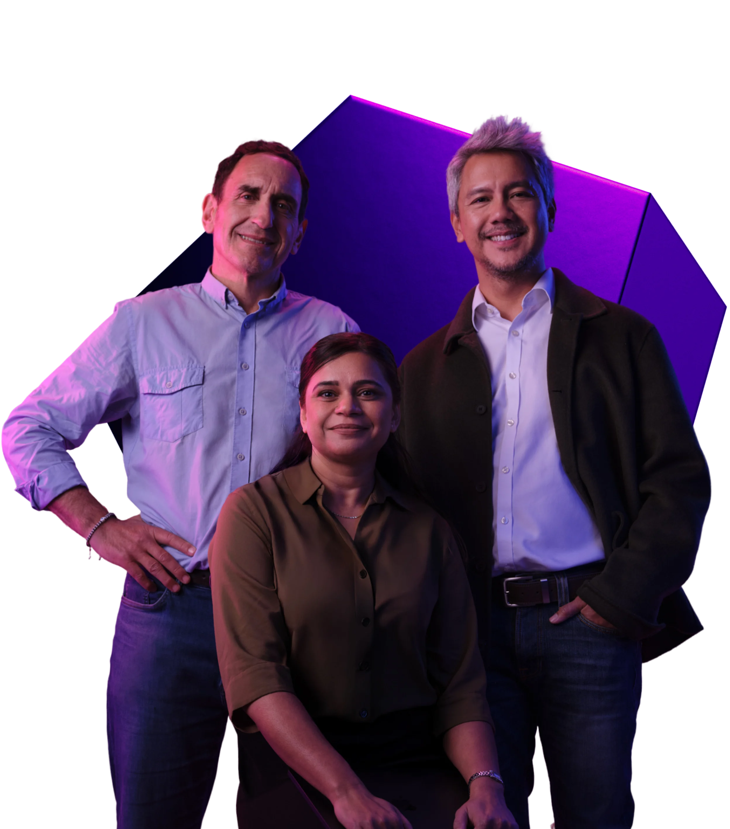 Three professionals smiling together against a purple geometric background with dramatic lighting.