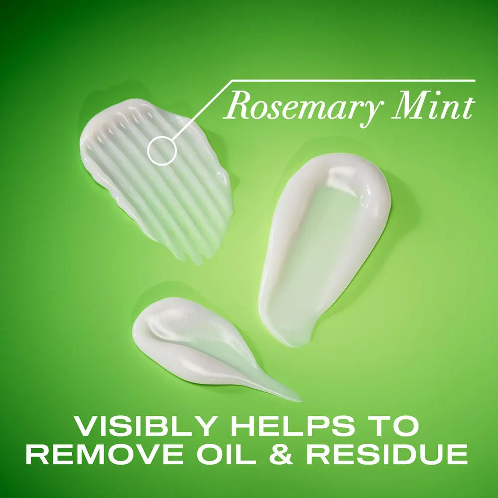 OGX® Rosemary Mint Extra Strength Conditioner product smears on a green background