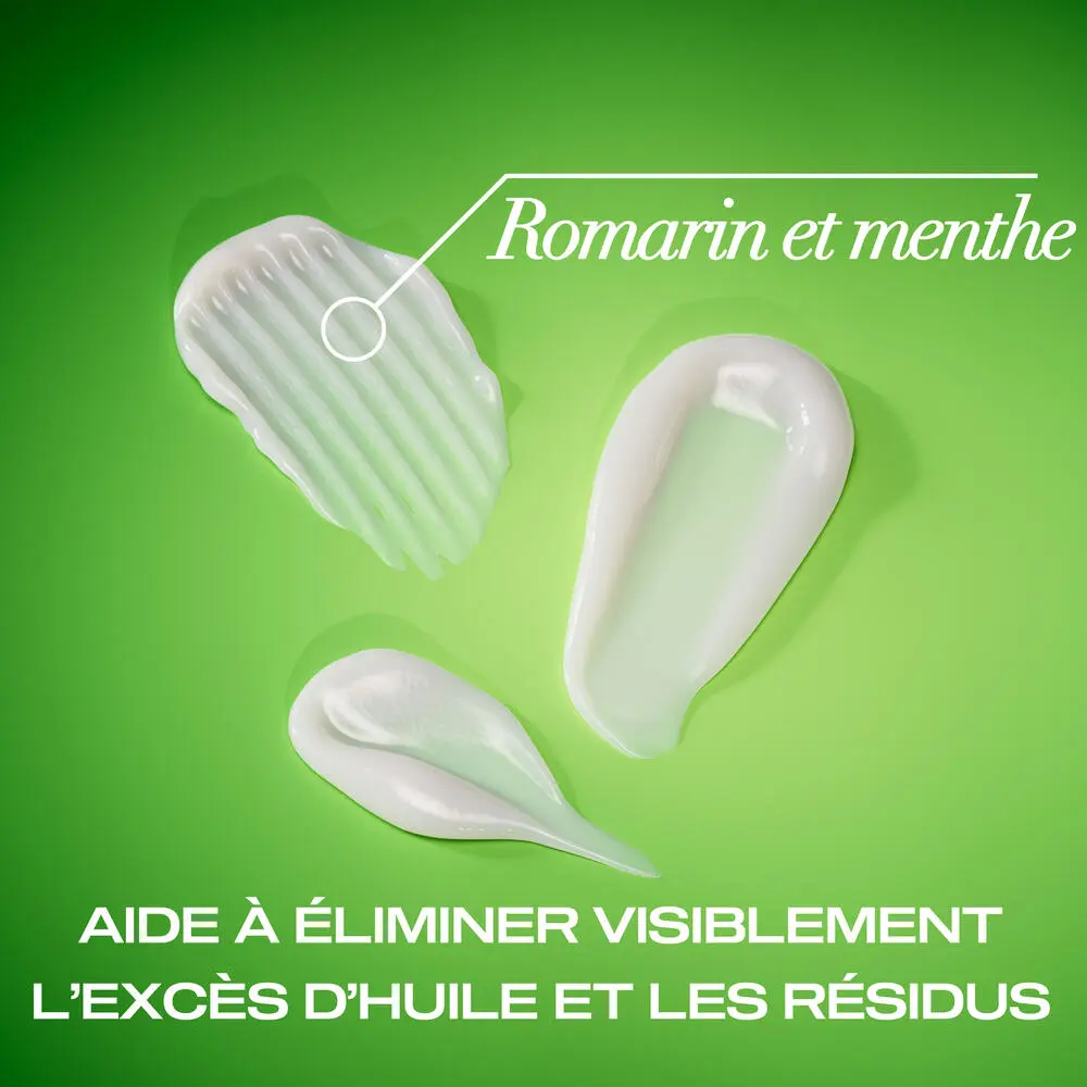 Traînées de revitalisant extra fort romarin et menthe OGX® sur un fond vert